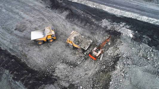 采石场的煤矿开采.液压挖掘机装载自卸车.照片